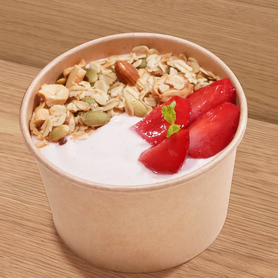 A cup of FOJO strawberry yogurt topped with granola and fresh strawberries
