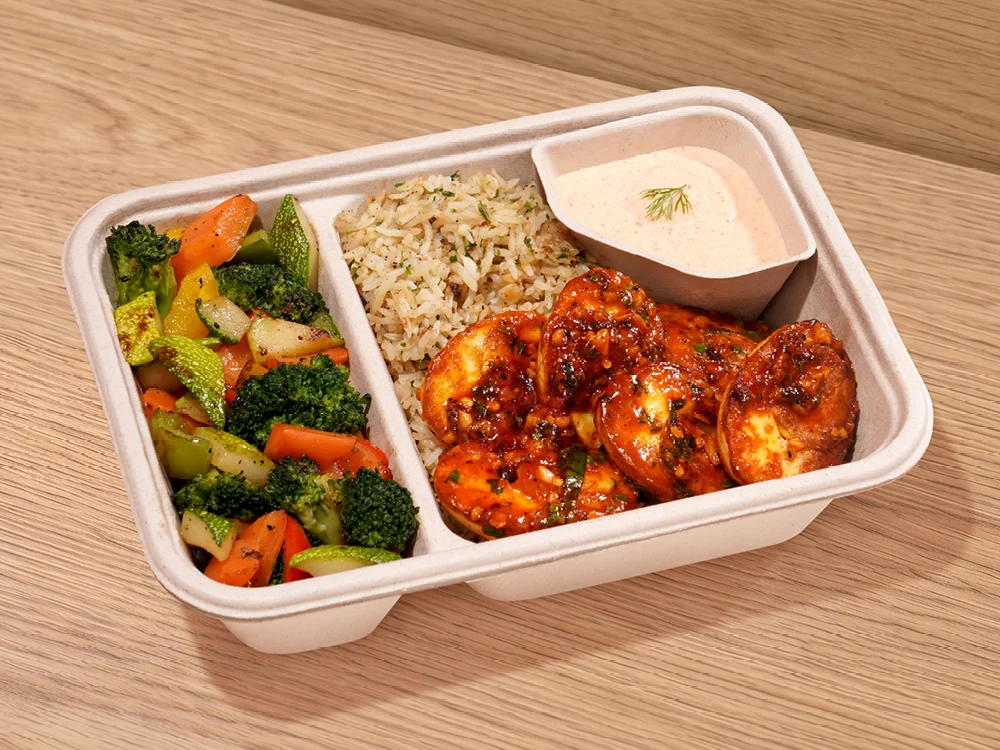 A Joy Bowl tray with rice, chilli chicken and a side of greens