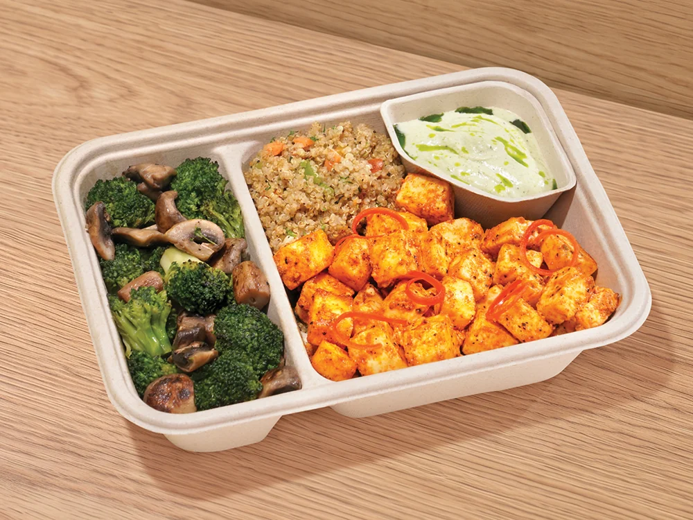 A Joy Bowl tray with sauteed vegetables, rice and a yogurt dip