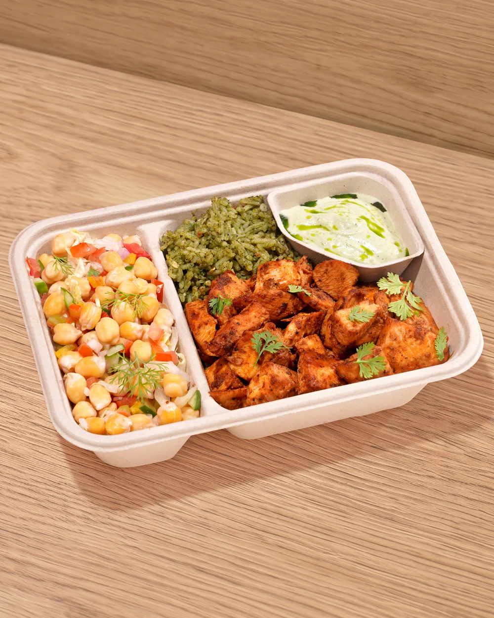 A FOJO Joy Bowl tray: chilli chicken, herbed rice, a chickpea salad and a dip