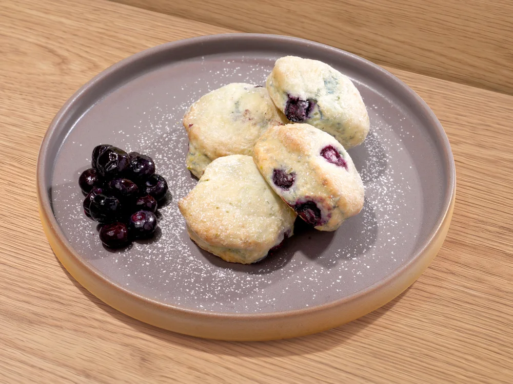 Blueberry scones on a plate with a side of blueberries