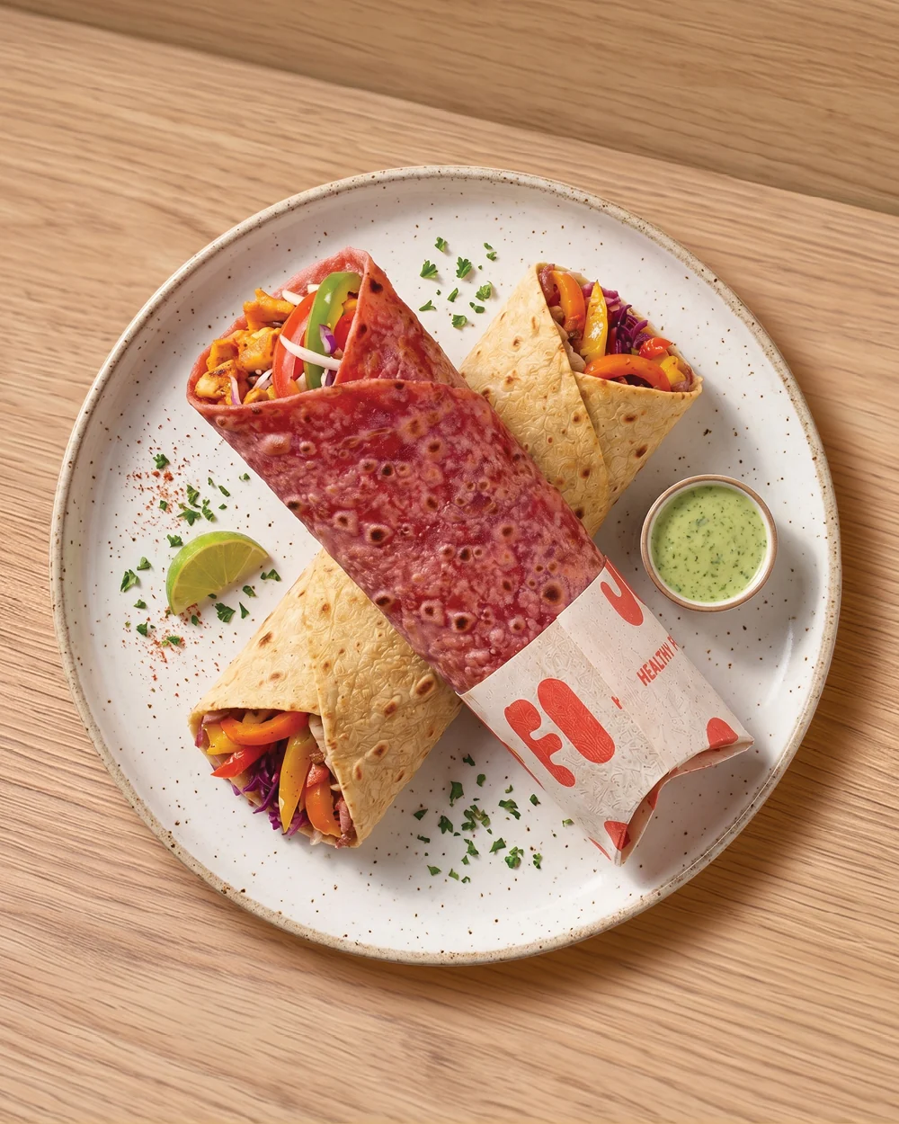 A FOJO wrap cut and plated with a green yogurt dip